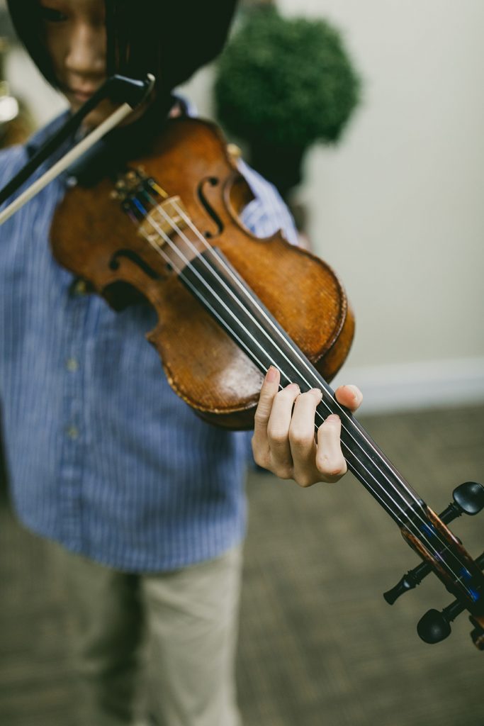 a young student playing the violin in a music lesson